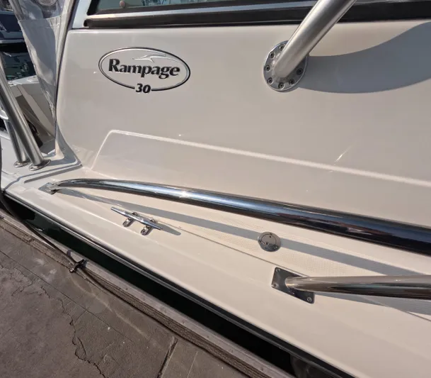 Alibi Yacht Photos Pics 2006 Rampage Express Offshore Tower boat side view with logo and chrome railing.