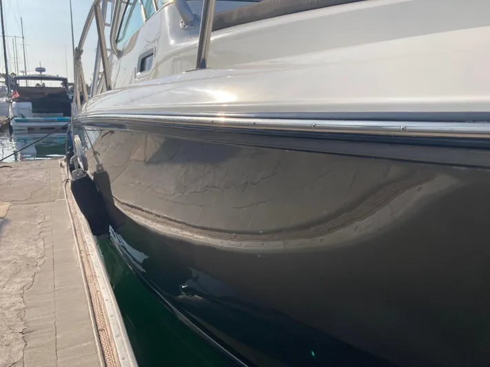 Alibi Yacht Photos Pics 2006 Rampage Express Offshore Tower boat docked at marina, side view.