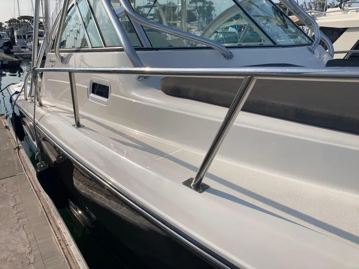 Alibi Yacht Photos Pics 2006 Rampage Express Offshore Tower boat docked at marina, showcasing sleek design and stainless steel railings.