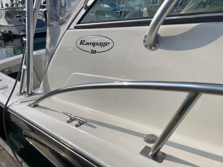 Alibi Yacht Photos Pics 2006 Rampage Express Offshore Tower boat with sleek metal railings and logo.