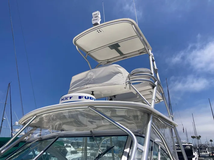 Alibi Yacht Photos Pics 2006 Rampage Express Offshore Tower boat with radar, docked under clear blue sky.
