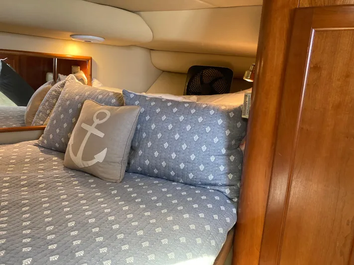 Alibi Yacht Photos Pics Cozy cabin interior of 2006 Rampage Express Offshore Tower with nautical-themed bedding.