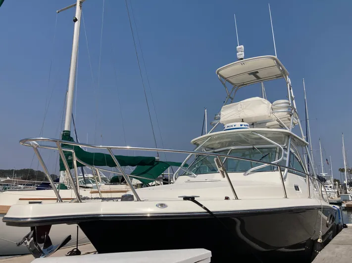 Alibi Yacht Photos Pics 2006 Rampage Express Offshore Tower boat docked at marina under clear blue sky.