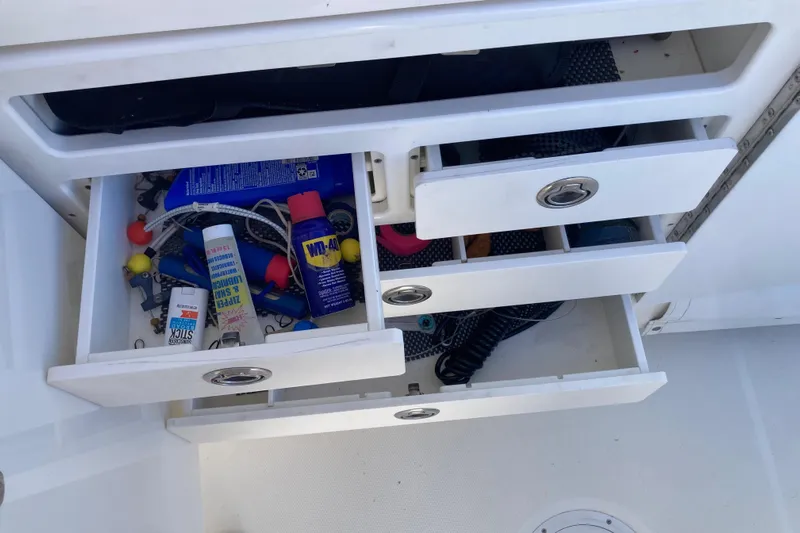 Alibi Yacht Photos Pics Open storage drawers on a 2006 Rampage Express Offshore Tower boat, containing various tools and supplies.