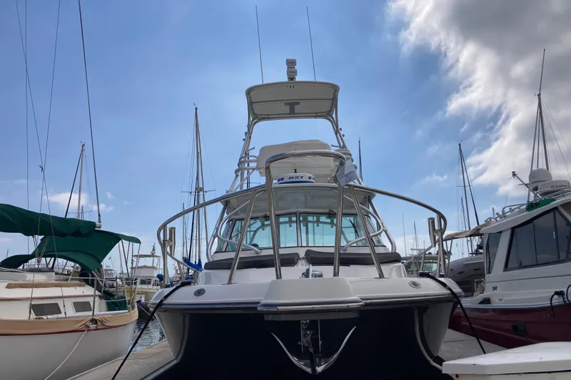 Alibi Yacht Photos Pics 2006 Rampage Express Offshore Tower boat docked at marina under blue sky.