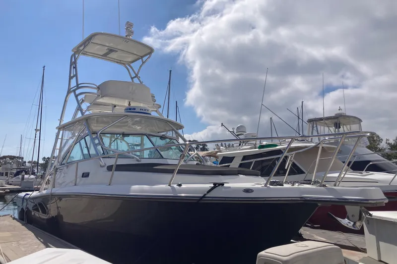 Alibi Yacht Photos Pics 2006 Rampage Express Offshore Tower boat docked at marina under cloudy sky.