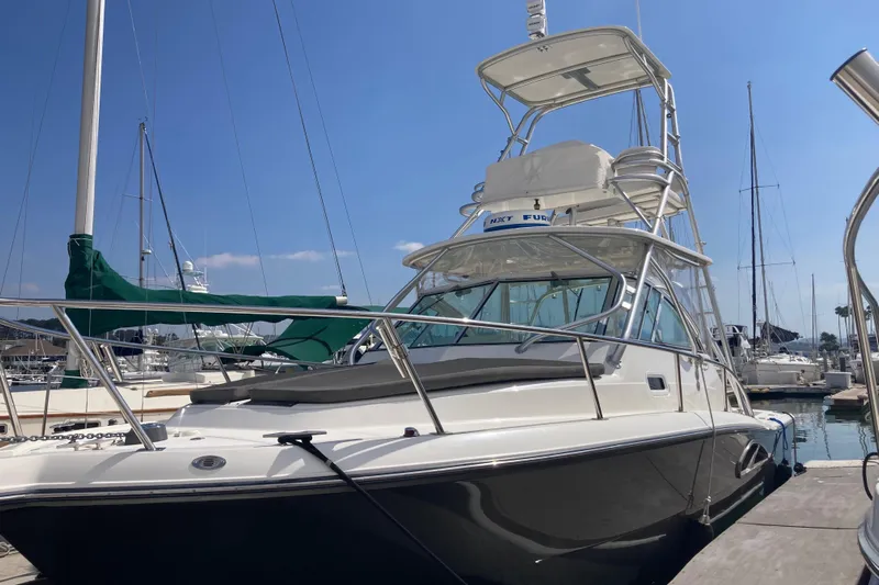 Alibi Yacht Photos Pics 2006 Rampage Express Offshore Tower boat docked at marina under clear blue sky.