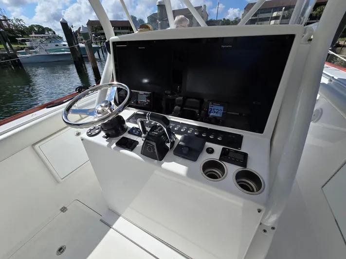  Yacht Photos Pics 2017 Buddy Davis 34 boat helm with steering wheel and control panel in marina setting.