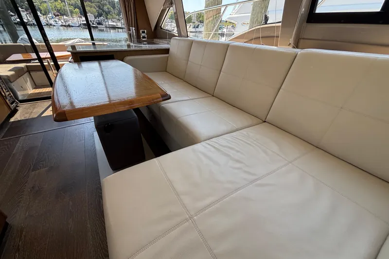 Cop Out II Yacht Photos Pics Luxurious interior of 2018 Sea Ray Sundancer 460 yacht with plush seating and wooden table.