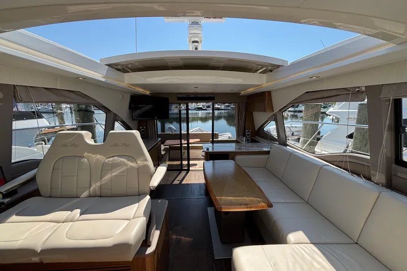 Cop Out II Yacht Photos Pics Luxurious interior of 2018 Sea Ray Sundancer 460 yacht with elegant seating and marina view.