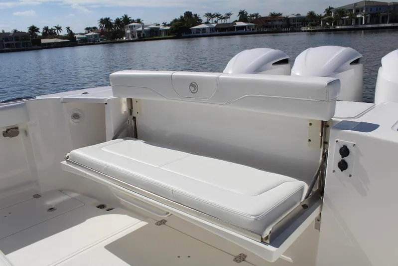  Yacht Photos Pics 2019 Edgewater 370CC boat with foldable white bench seat by the water.