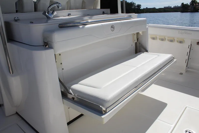  Yacht Photos Pics 2019 Edgewater 370CC boat with fold-out seating and sink, docked by the water.