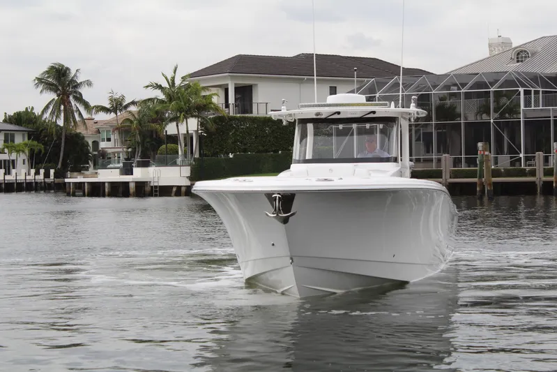  Yacht Photos Pics 2019 Edgewater 370CC boat cruising near waterfront homes.