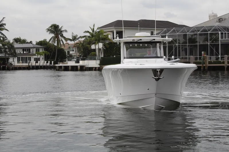  Yacht Photos Pics 2019 Edgewater 370CC boat cruising in a scenic waterfront area.