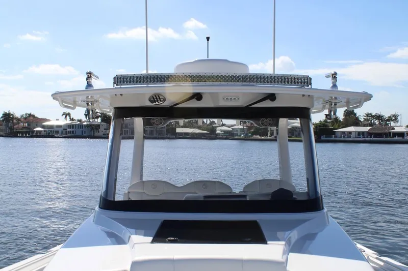  Yacht Photos Pics 2019 Edgewater 370CC boat on calm water with waterfront homes in background.