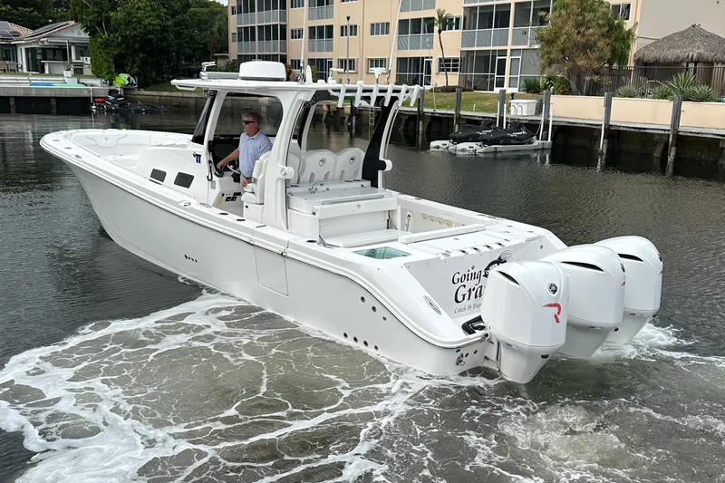  Yacht Photos Pics 2019 Edgewater 370CC boat with triple engines cruising in a marina.