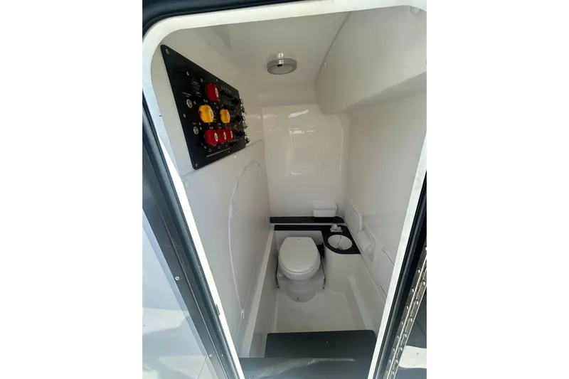  Yacht Photos Pics 2023 Fountain 38TE CC boat interior with toilet and control panel.