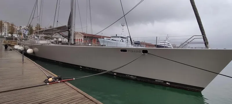 Syl Yacht Photos Pics Sleek 2003 custom sports yacht docked at a marina under cloudy skies.