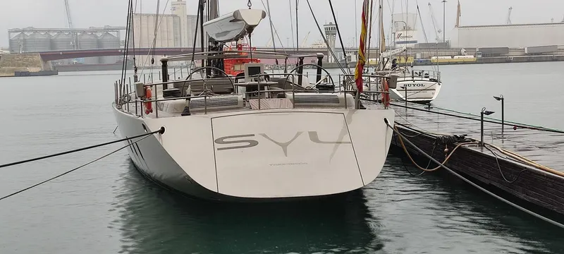 Syl Yacht Photos Pics Custom 2003 SYL sports boat docked at a marina, showcasing sleek design and modern features.