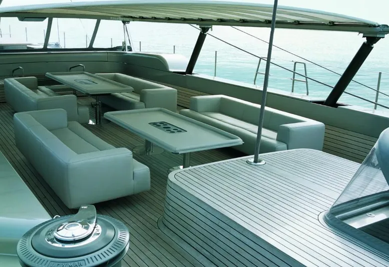 Syl Yacht Photos Pics Luxurious 2003 custom yacht deck with modern seating and tables, featuring sleek design elements.