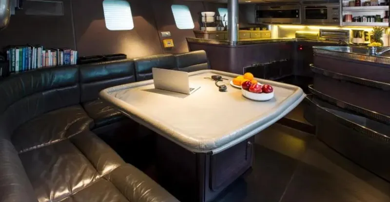 Syl Yacht Photos Pics Luxurious yacht interior with leather seating, dining table, and modern kitchen.