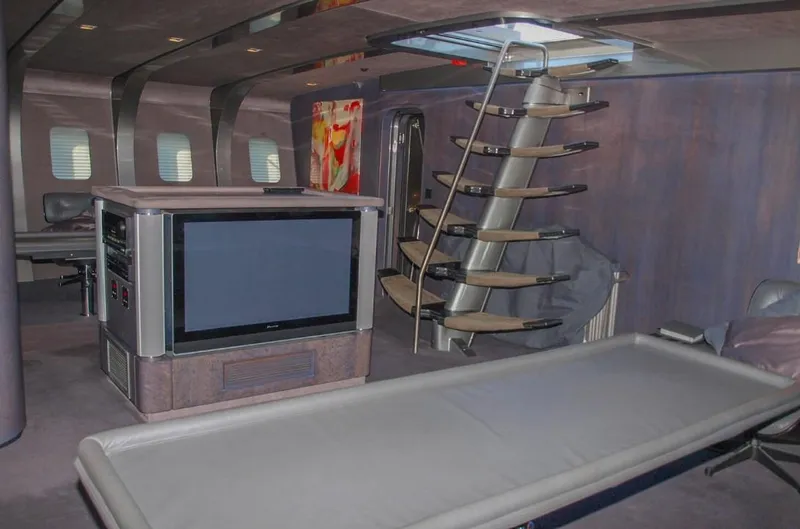 Syl Yacht Photos Pics Luxurious yacht interior with modern design, featuring a large TV and stylish staircase, 2003 model.