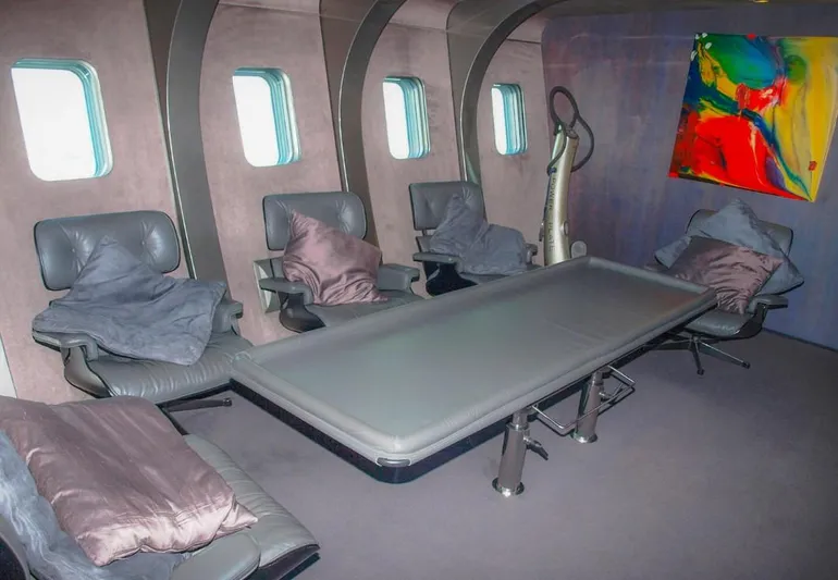 Syl Yacht Photos Pics Luxurious yacht interior with leather seating, modern table, and colorful abstract art.