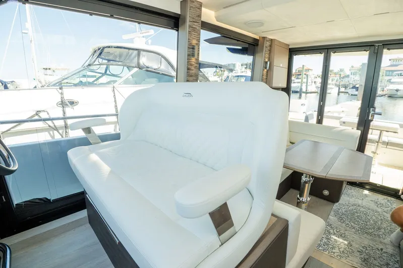  Yacht Photos Pics Luxurious interior of 2025 Galeon 400 Fly yacht with white seating and marina view.