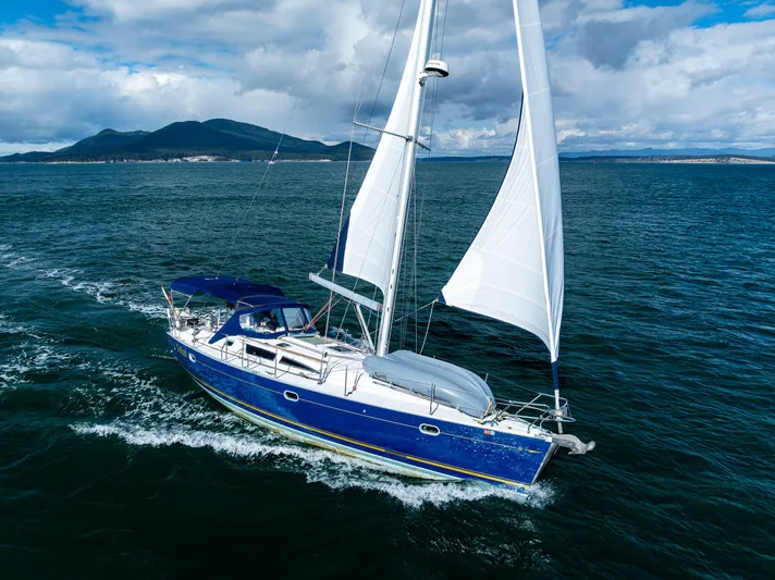 Salus Yacht Photos Pics Sailing yacht Jeanneau Sun Odyssey 40, 2001 model, cruising on open water under clear skies.