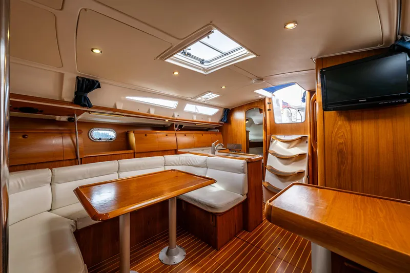 Salus Yacht Photos Pics Interior of 2001 Jeanneau Sun Odyssey 40 yacht with wood finish and seating area.