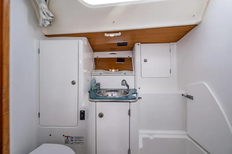 Salus Yacht Photos Pics 2001 Jeanneau Sun Odyssey 40 yacht bathroom with sink, cabinets, and white interior.