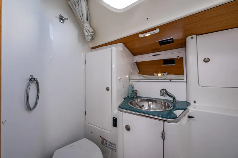 Salus Yacht Photos Pics 2001 Jeanneau Sun Odyssey 40 yacht bathroom with sink, toilet, and storage cabinets.