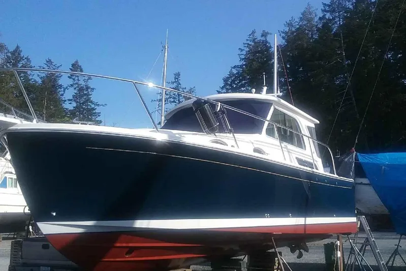 Lady In Blue Yacht Photos Pics 2012 Back Cove 30 boat on land, blue hull, red bottom, trees in background.