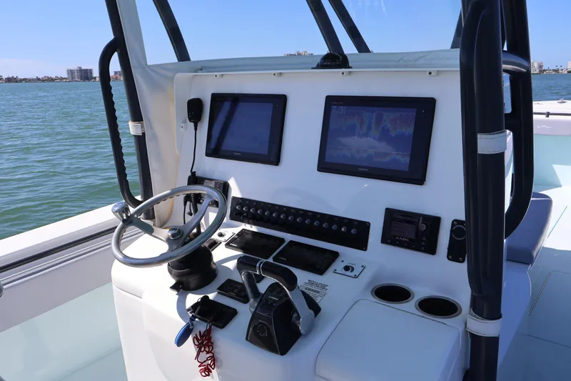 Wine Down Yacht Photos Pics 2017 Contender 35 ST boat dashboard with navigation screens and steering wheel on open water.