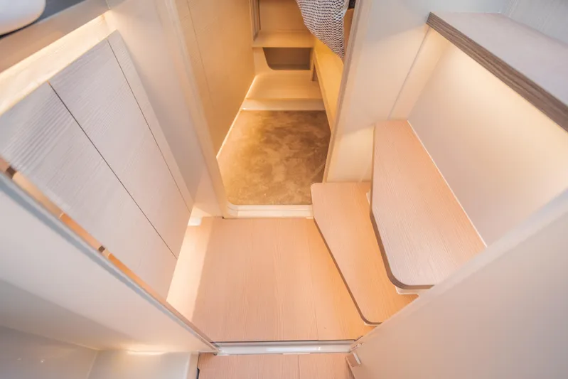  Yacht Photos Pics Modern interior of 2025 Catana YOT 36 yacht with sleek wooden steps and ambient lighting.