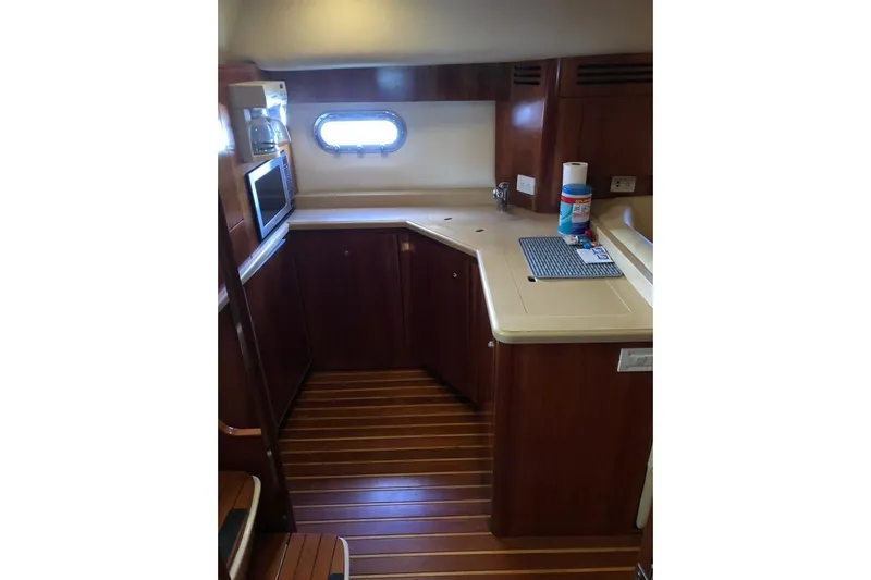 Eye Catcher Yacht Photos Pics 2004 Tiara Yachts 4400 Sovran galley with wood cabinetry and modern appliances.