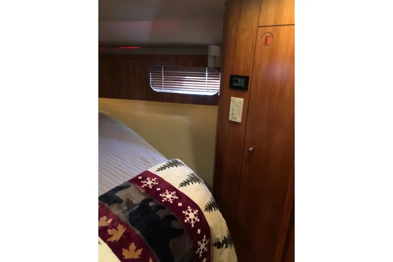 Eye Catcher Yacht Photos Pics Interior cabin of 2004 Tiara Yachts 4400 Sovran with wood paneling and cozy bedding.