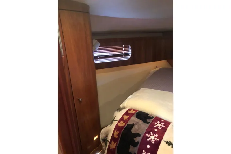 Eye Catcher Yacht Photos Pics 2004 Tiara Yachts 4400 Sovran cabin interior with wooden paneling and cozy bedding.