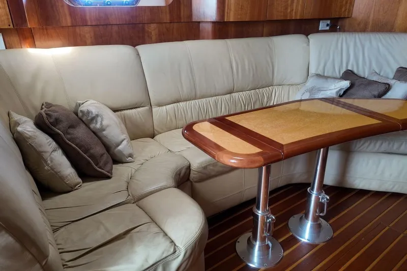 Eye Catcher Yacht Photos Pics Luxurious interior of 2004 Tiara Yachts 4400 Sovran with leather seating and wooden table.