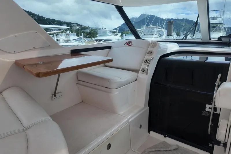 Eye Catcher Yacht Photos Pics Interior of 2004 Tiara Yachts 4400 Sovran with white seating and wooden table.
