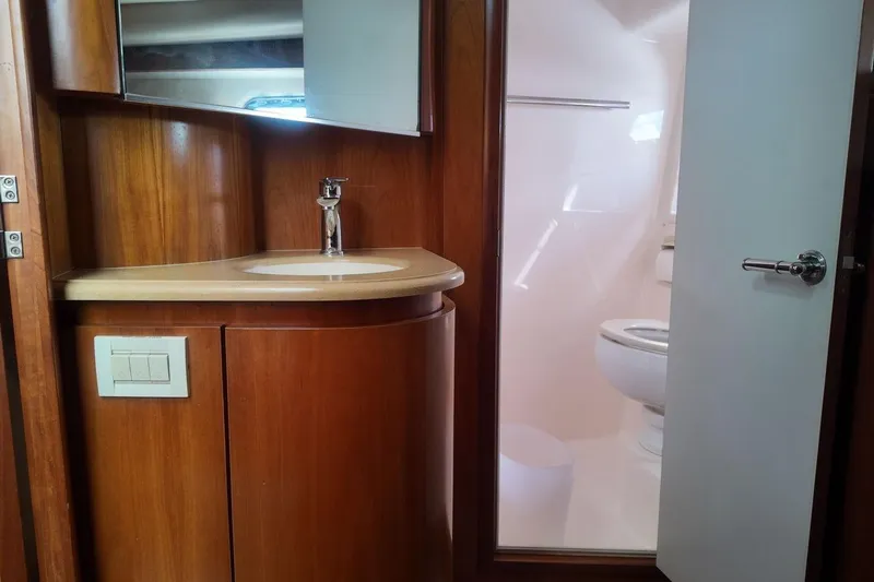 Eye Catcher Yacht Photos Pics 2004 Tiara Yachts 4400 Sovran bathroom with wooden cabinetry and modern fixtures.
