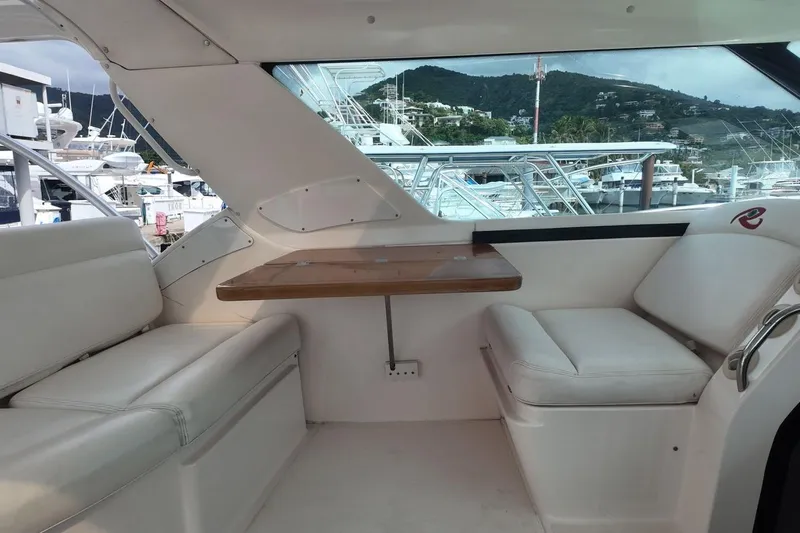 Eye Catcher Yacht Photos Pics Interior of 2004 Tiara Yachts 4400 Sovran with white seating and wooden table.