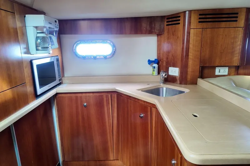 Eye Catcher Yacht Photos Pics 2004 Tiara Yachts 4400 Sovran kitchen with wood cabinetry, microwave, and sink.
