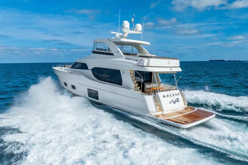 Mocean Yacht Photos Pics 2021 Ocean Alexander 70E Motoryacht cruising on open sea under clear blue sky.