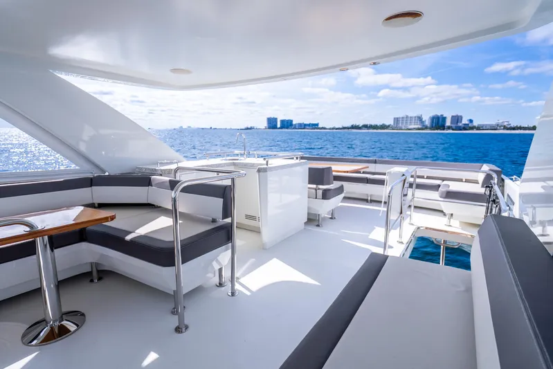Mocean Yacht Photos Pics Luxurious 2021 Ocean Alexander 70E Motoryacht deck with seating, ocean view, and city skyline.