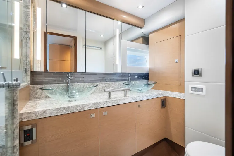 Mocean Yacht Photos Pics Luxurious bathroom in 2021 Ocean Alexander 70E Motoryacht with dual glass sinks and modern fixtures.