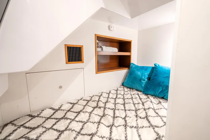 Mocean Yacht Photos Pics Cozy cabin interior of 2021 Ocean Alexander 70E Motoryacht with blue pillows and shelving.