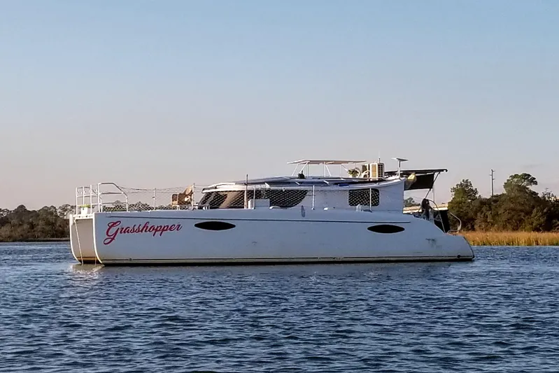 Grasshopper Yacht Photos Pics 2011 Fountaine Pajot Orana 44 Grand Large catamaran named "Grasshopper" on calm water.