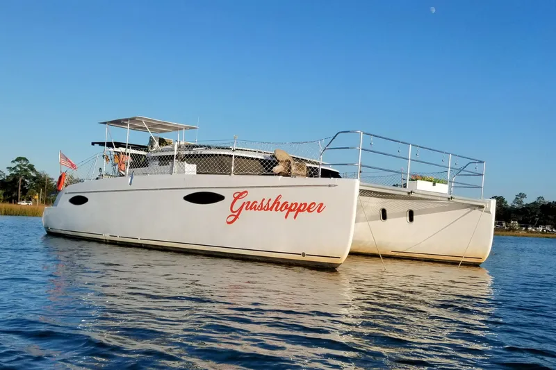 Grasshopper Yacht Photos Pics 2011 Fountaine Pajot Orana 44 Grand Large catamaran named "Grasshopper" on calm water.