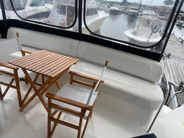  Yacht Photos Pics 2006 Carver 430 Cockpit Motor Yacht interior with wooden table and chairs, marina view.